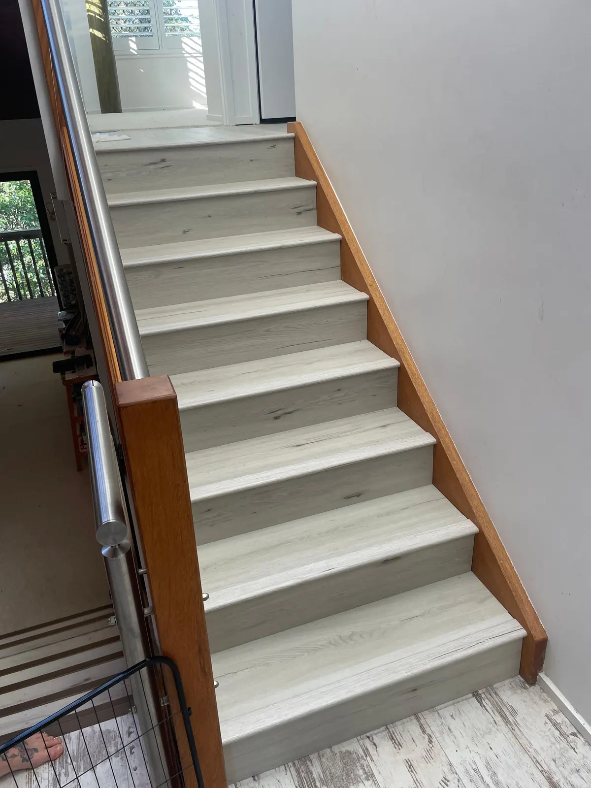 Finished staircase with pale treads and a timber stringer