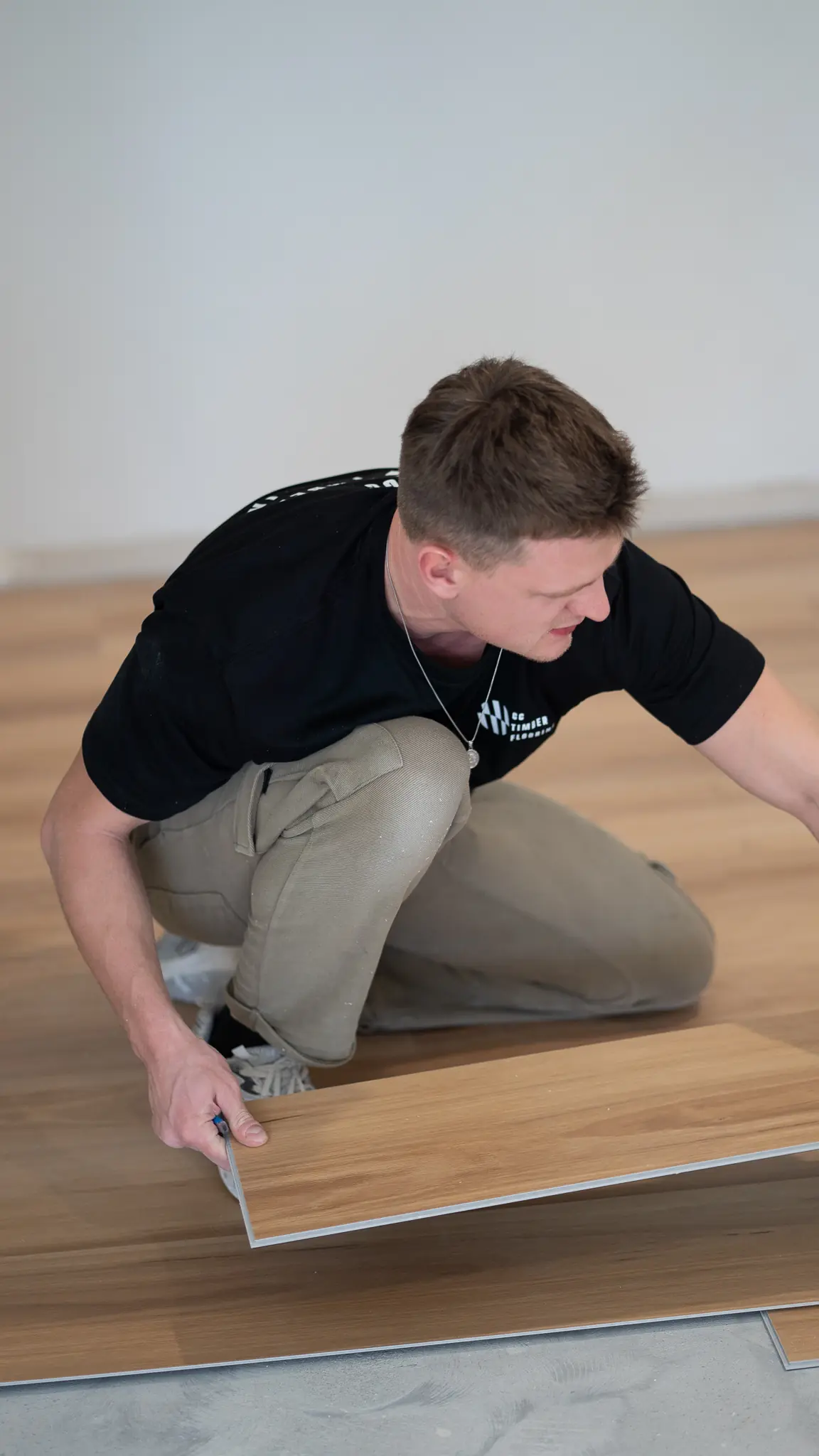Installer marking a plank before cutting it to size