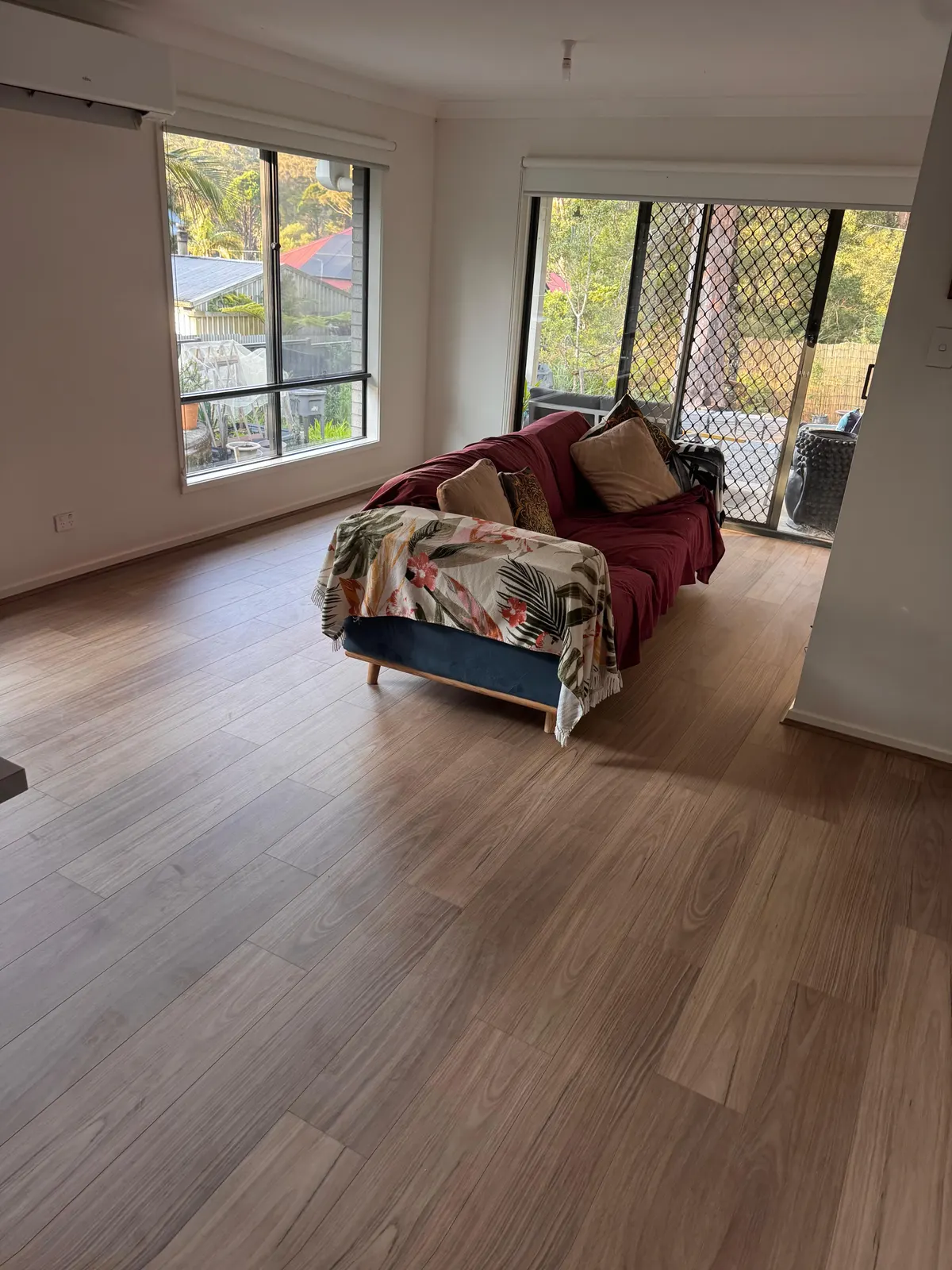 Laminate flooring in a living room with large windows