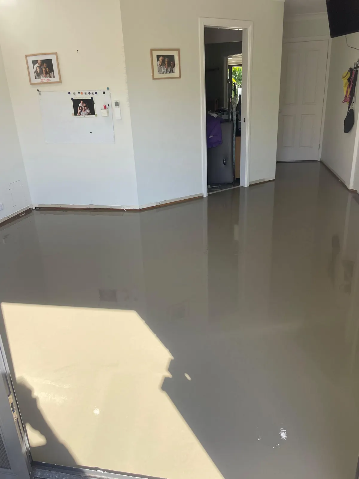 Freshly poured levelling compound across a living room floor