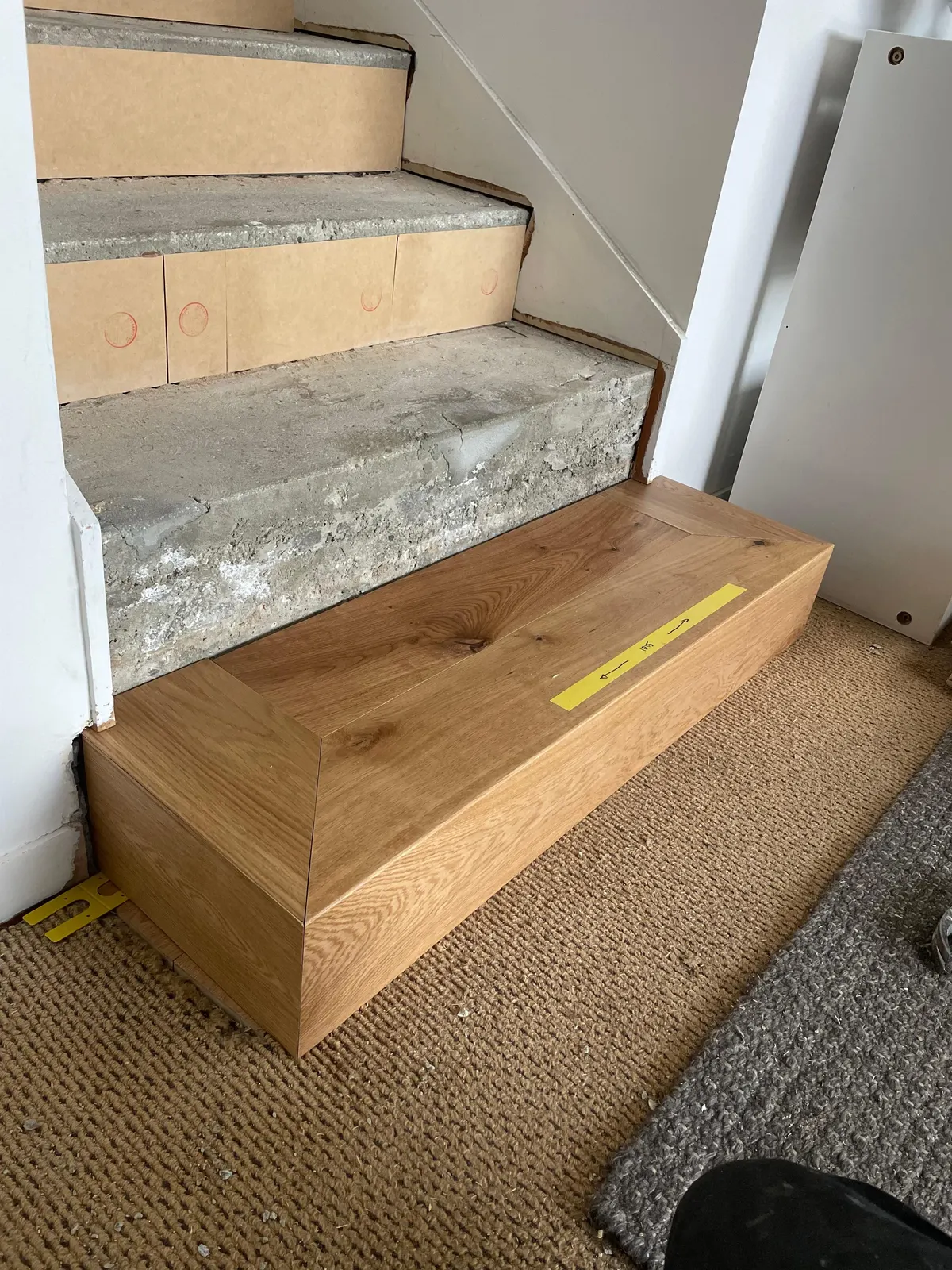 Concrete stairs during preparation with the first timber tread fitted