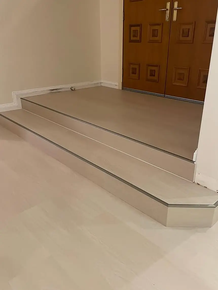 Light oak-look flooring on a stepped entry finished with metal edge trims