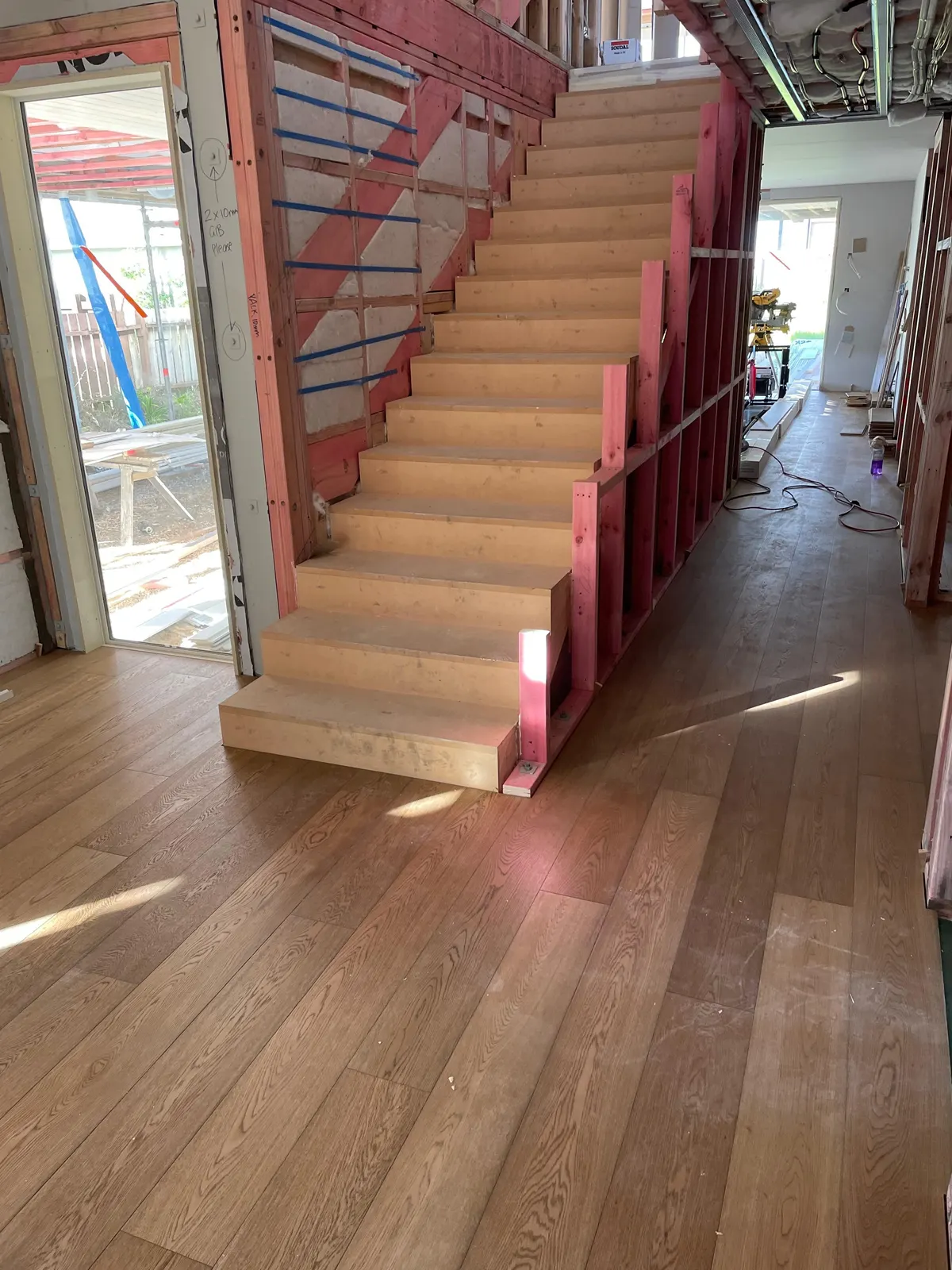 Timber floor laid through a new build beside a timber staircase